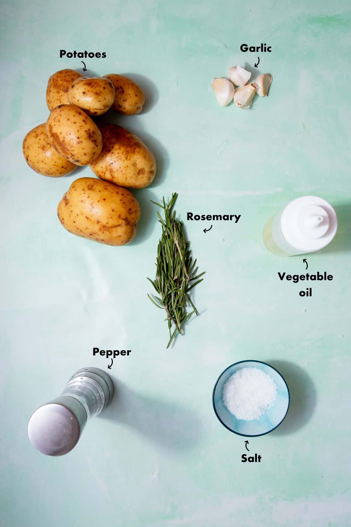 Ingredients to make the parmentier potatoes laid out on a plae blue background and labelled.