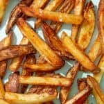 Golden browned baked potato chips on a pale blue background.