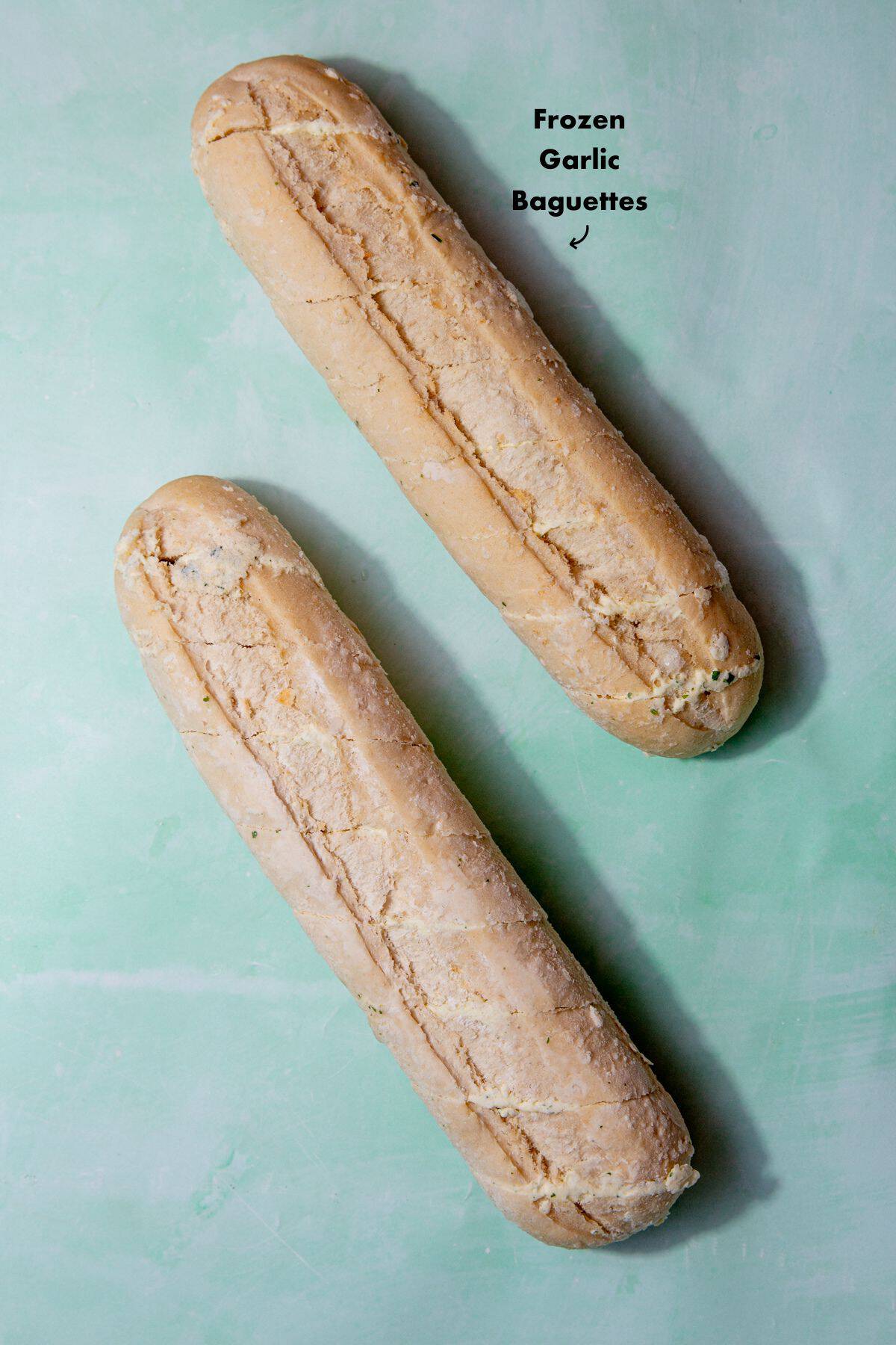 2 frozen garlic bread baguettes laid out on a pale blue background and labelled.