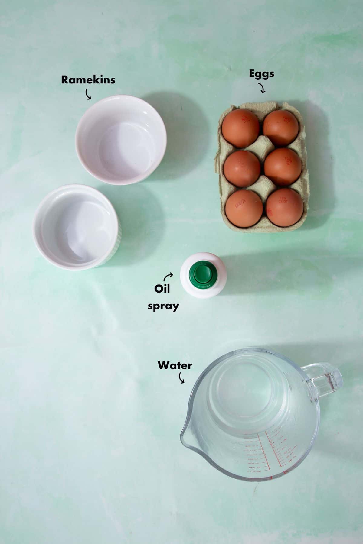 Ingredients for make the air fryer poached eggs laid out on a pale blue background and labelled.