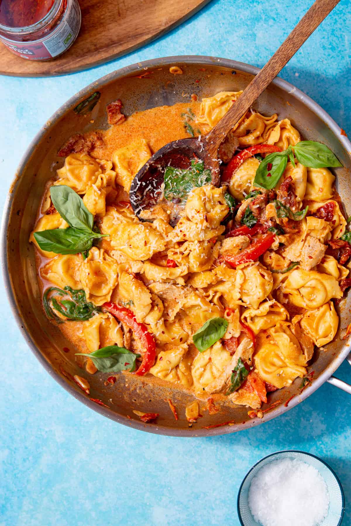 marry me chicken tortellini in a skillet on a blue background