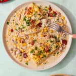feature image of smoked haddock recipe served with a creamy sauce, corn, bacon, and topped with parsley.