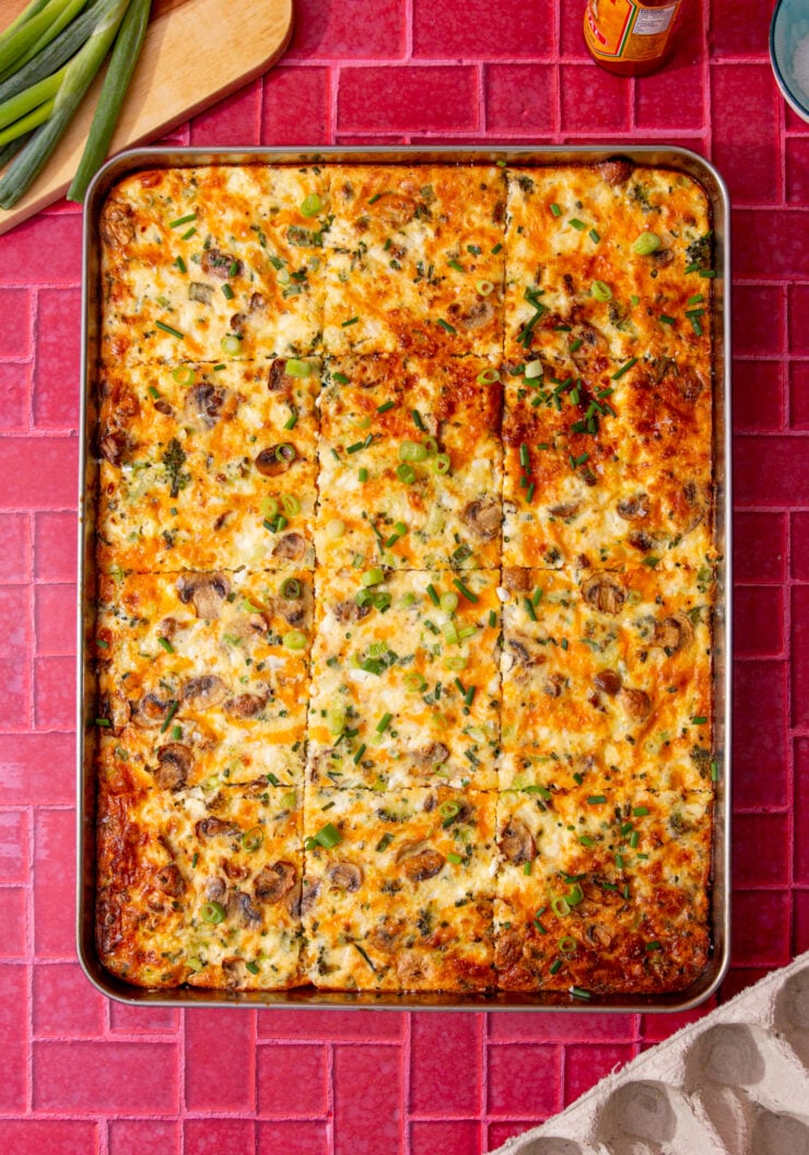 fully baked and golden brown sheet pan eggs on a red background