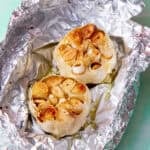 two roasted garlic bulbs in foil