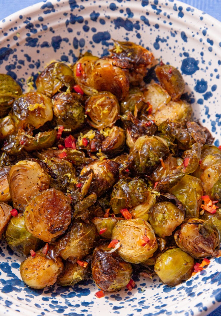 honey balsamic brussel sprouts in a blue and white speckled bowl