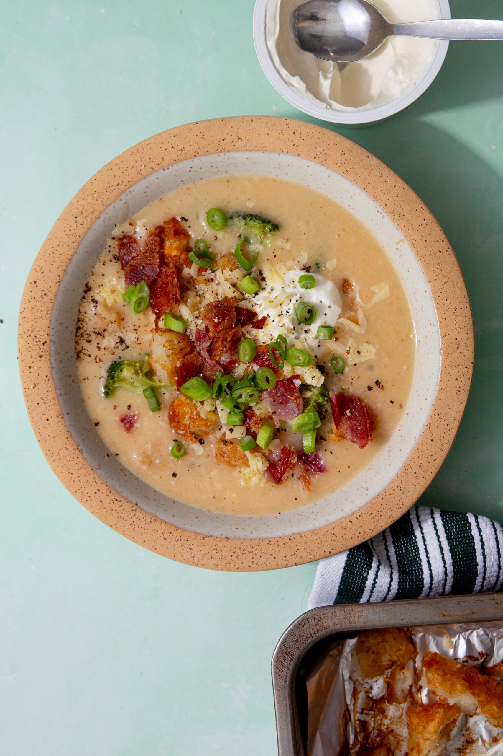prepared hash brown potato soup in a speckled bowl on a light green background