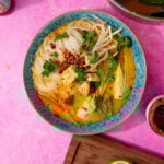 prepared chicken laksa soup in a blue bowl on a purple background
