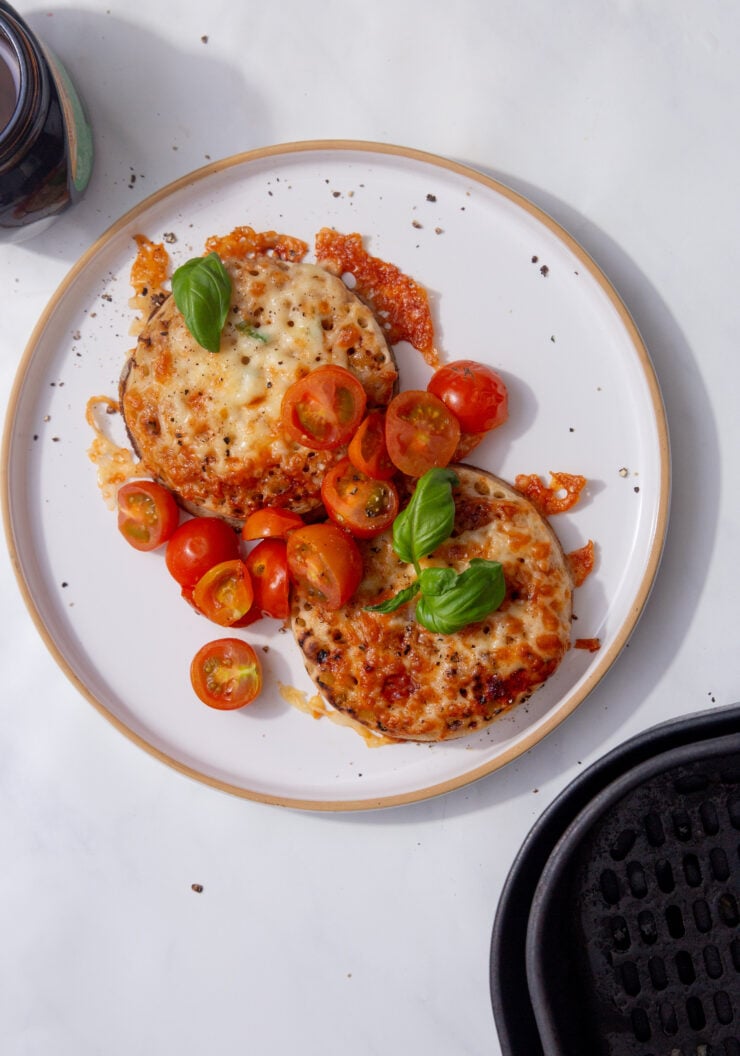 image of crumpets with melted cheese marmite, butter, cherry tomatoes, and basil