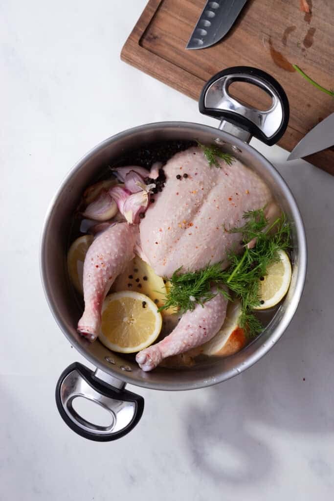 Dill, lemon and peppercorns added to the stock pot with the chicken. 
