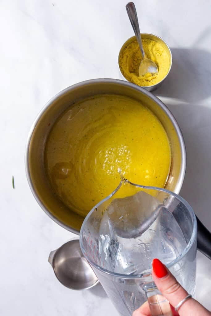 Water and bouillon powder being mixed in a saucepan. 