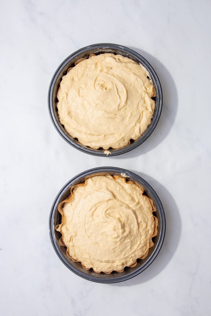cake mix poured into two parchment lined cake tins. 