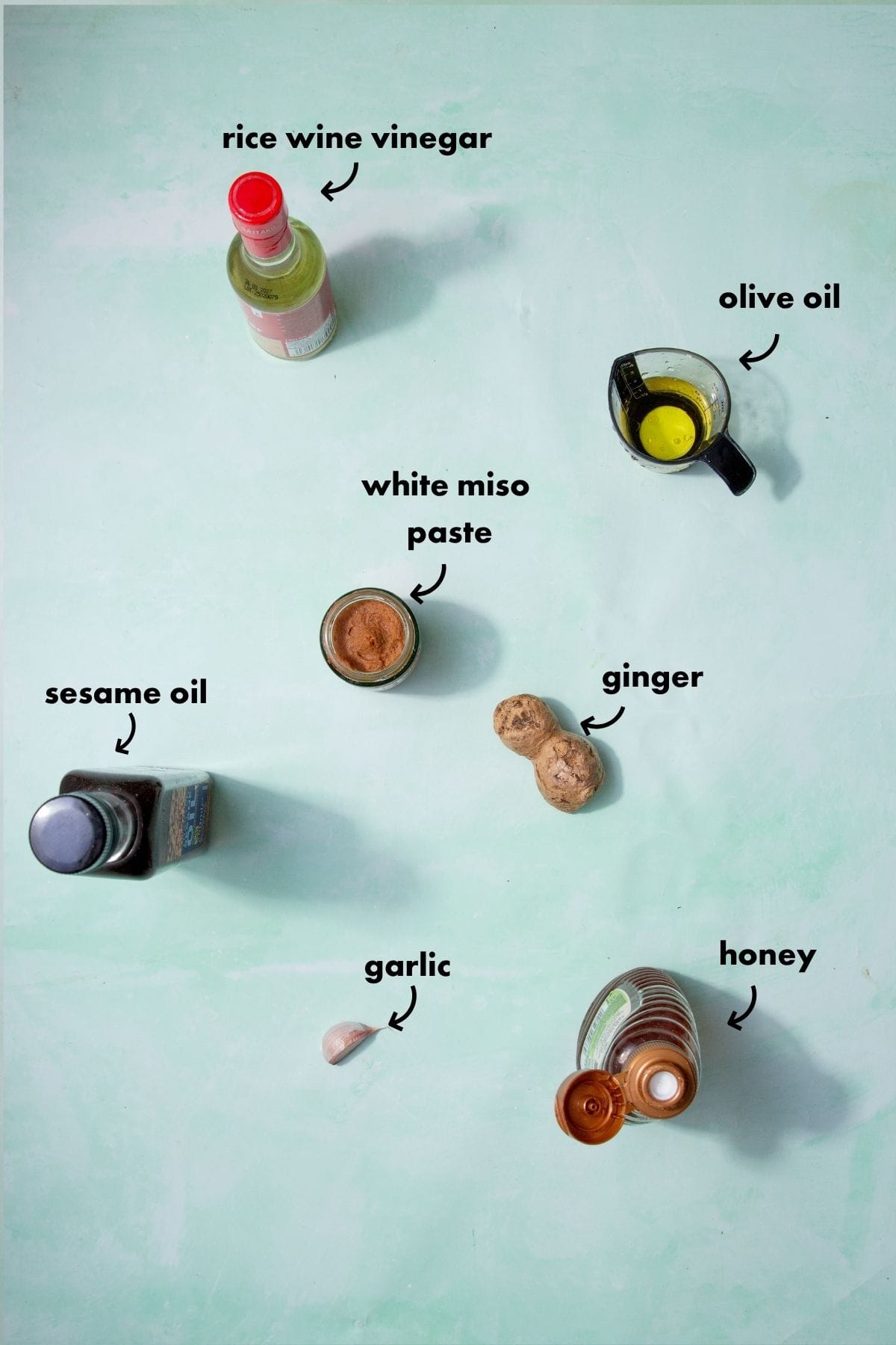 Ingredients for miso dressing recipe including white miso paste, sesame oil, rice vinegar, olive oil, garlic, ginger and honey.