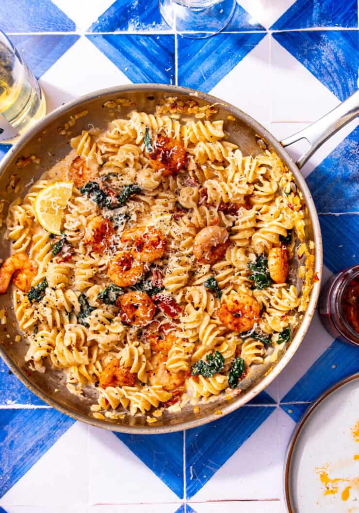Creamy marry me shrimp pasta with shrimp, cavolo nero, sun-dried tomatoes, and parmesan in a skillet.