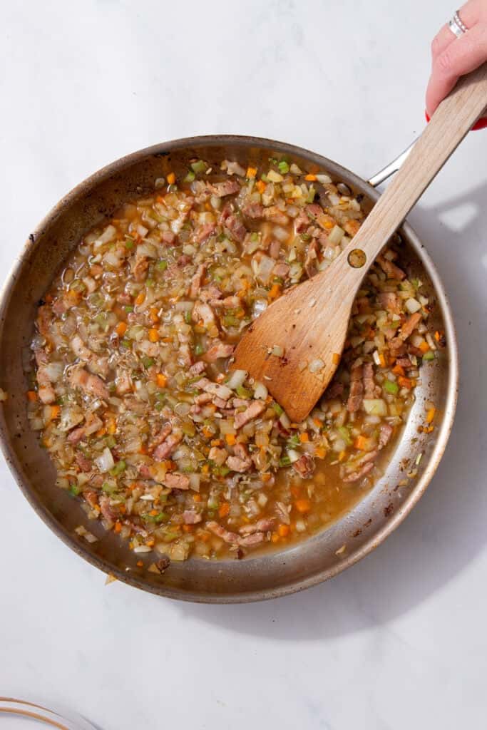 Pancetta, onion, carrot and celery cooking together with dried herbs.