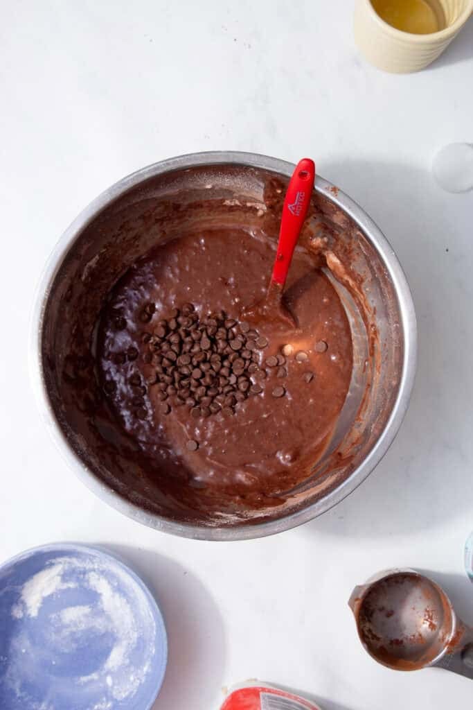 Stirring chocolate chips through the rich chocolate protein muffin batter.