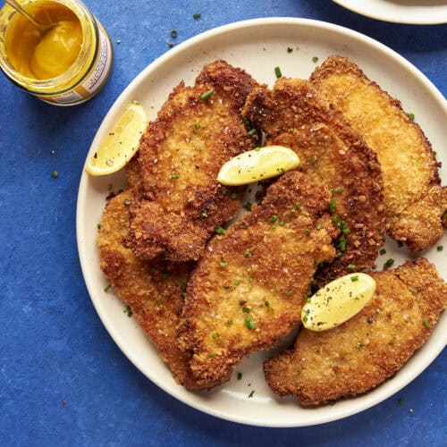 A plate of fried food served with a side of roasted corn.