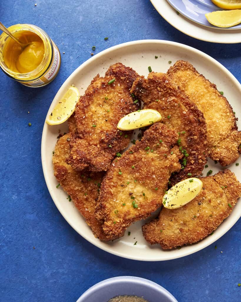 A plate of fried food served with a side of roasted corn.