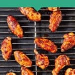 Soy chicken wings coated in a glossy garlic soy glaze are arranged on a metal baking rack over a baking sheet. Text above reads Oven Baked Garlic Soy Chicken Wings—‘Couldn’t be easier’ and Perfect Every Time on a green background.