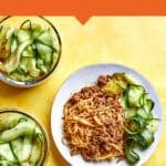 A plate of Peanut Sauce Noodles with ground protein and cucumber ribbons, surrounded by three meal prep containers with the same meal, on a yellow background. Text reads “Peanut Sauce Noodles (High Protein Lunch Meal Prep)”.