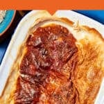 A baked rice pudding with a golden brown, slightly crispy top in a white dish, with a portion served out. Text reads IDEAL SUNDAY PUDDING and www.beatthebudget.com.