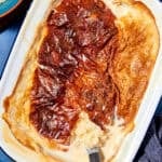 A baked rice pudding in a white dish with a golden brown top, partially served to reveal creamy rice underneath. Text reads “Rice Pudding Recipe,” highlighting this easy oven method and website link for the perfect homemade rice pudding.