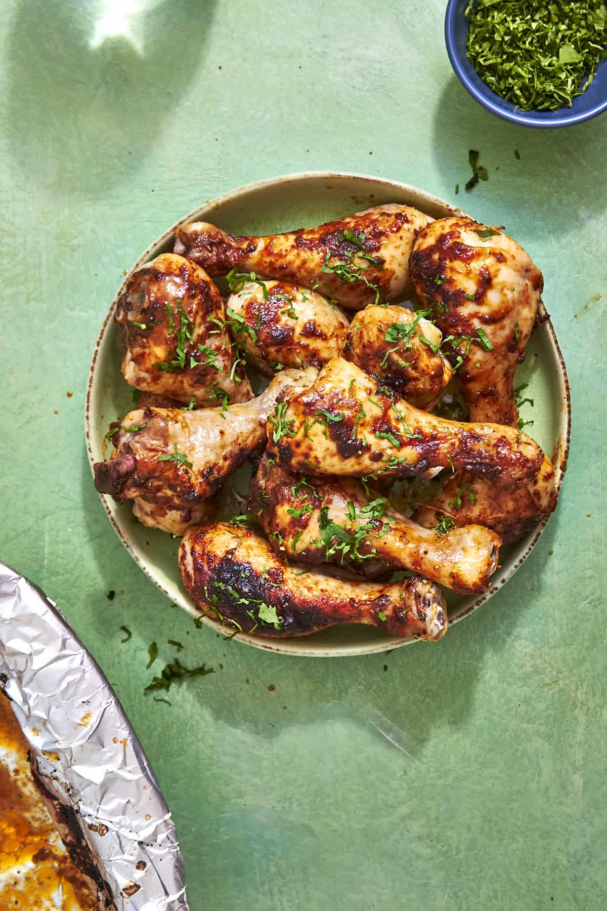 Close-up of golden crispy baked chicken drumsticks showing caramelised honey glaze