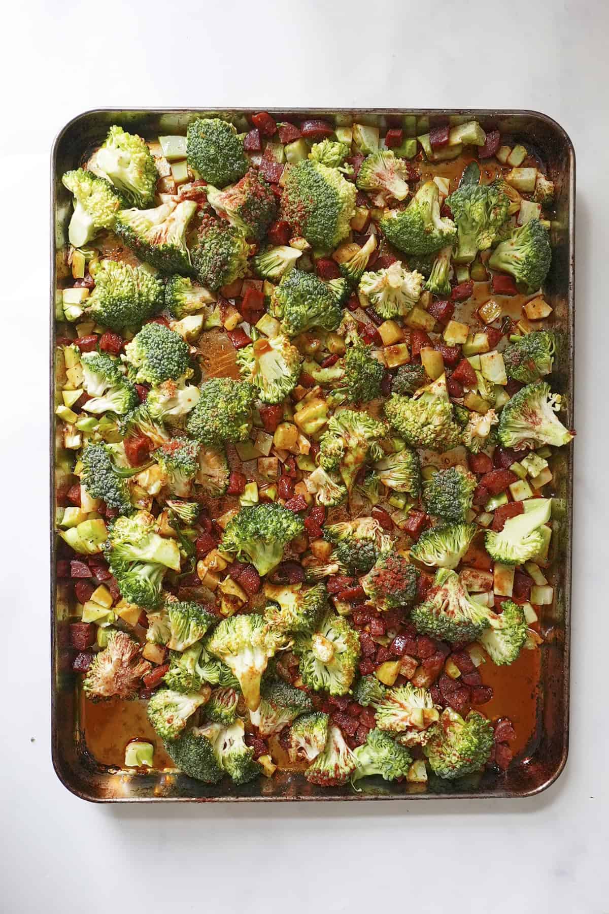 Broccoli florets added to the tray with smoked paprika and garlic granules
