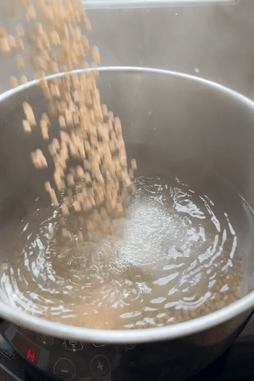 Giant couscous being rinsed under cold water after cooking