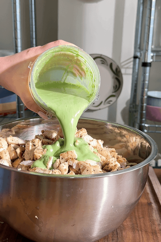 Shredded cabbage, cucumber, spring onion, couscous and chicken in a large mixing bowl