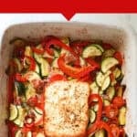 A white baking tray features baked feta pasta, topped with creamy feta cheese, zucchini, cherry tomatoes, and red bell peppers. Text above reads, Viral Baked Feta Pasta and High Protein Weeknight Dinner.