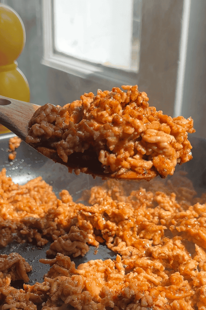 Hoisin sauce added to the chicken mince in the pan, darkening and thickening