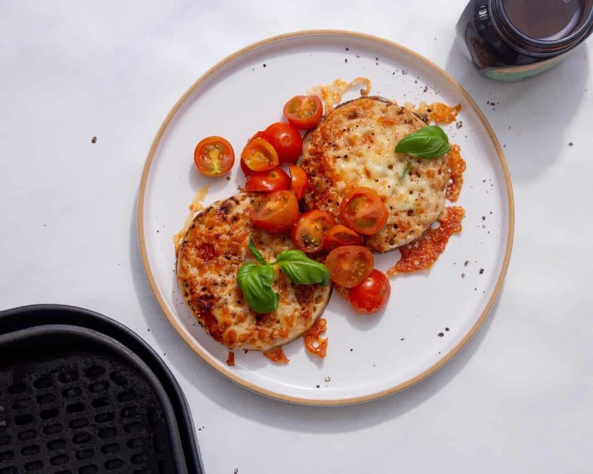 image of crumpets with melted cheese marmite, butter, cherry tomatoes, and basil
