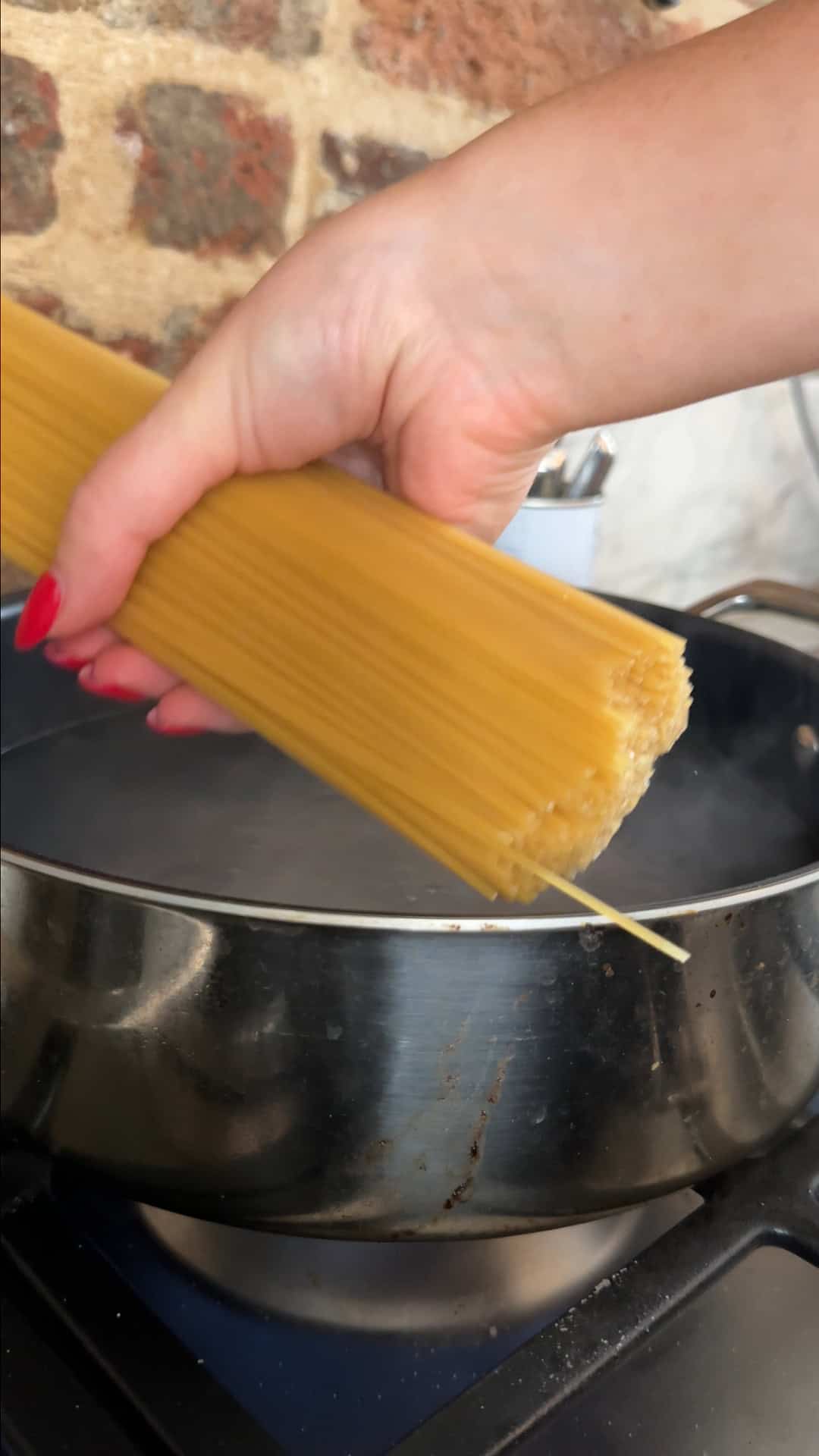 Spaghetti cooking in a pan of salted boiling water with bicarbonate of soda.
