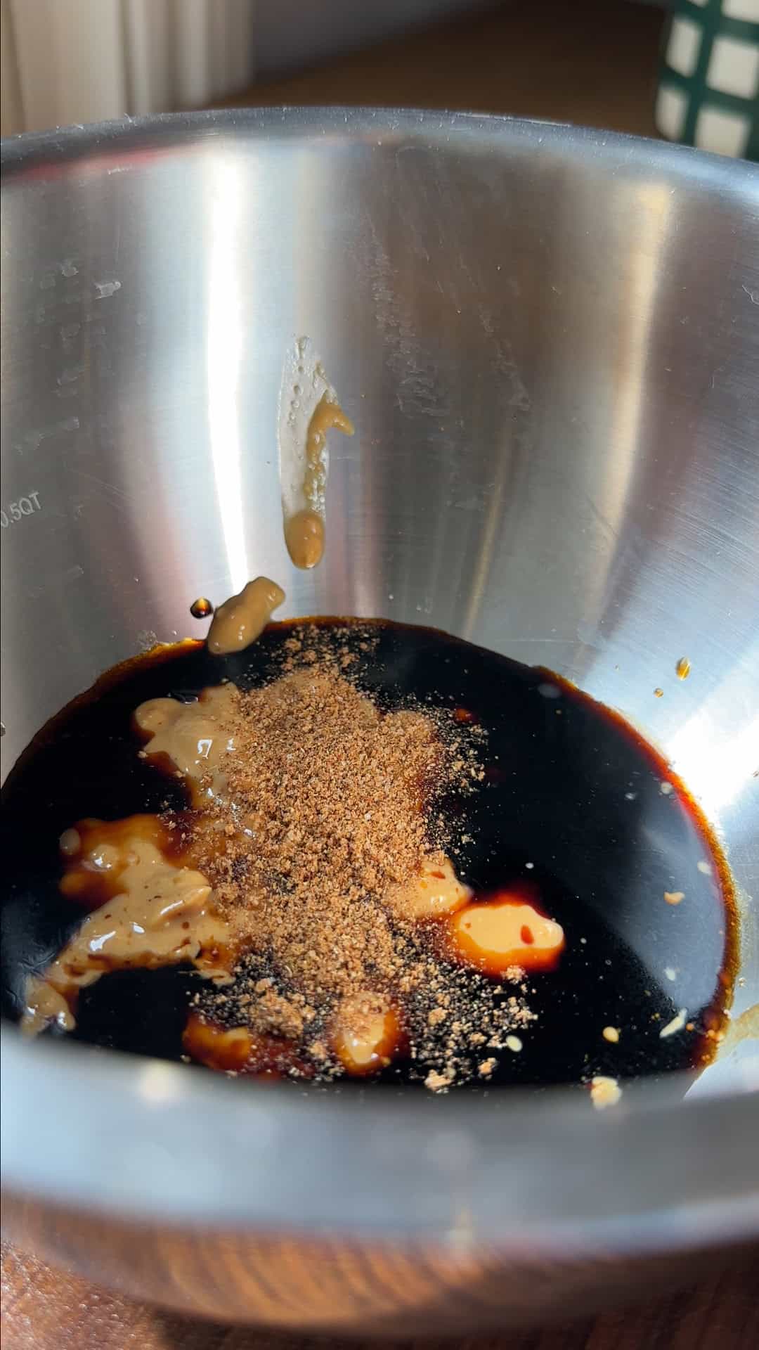 Dan dan sauce ingredients being whisked together in a small bowl.