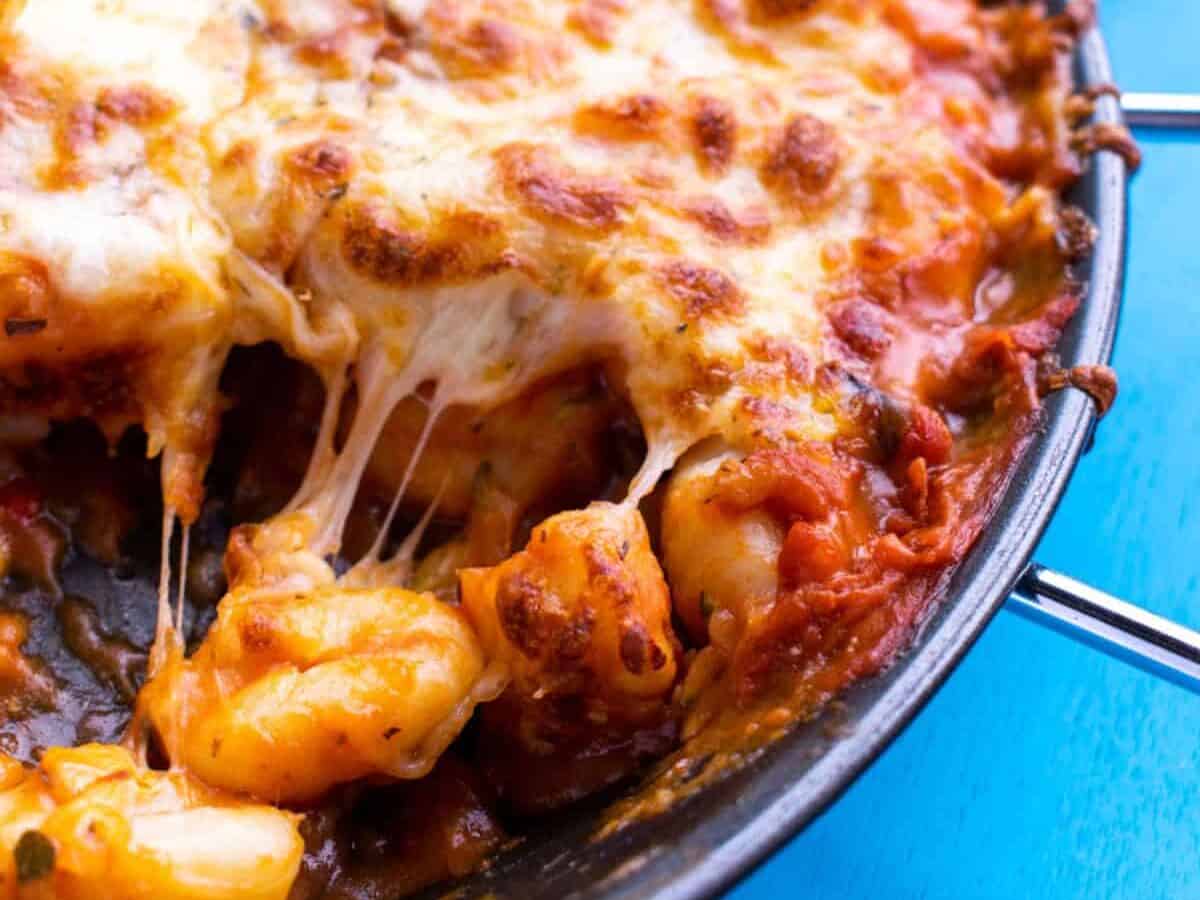 Cheesy Gnocchi in a pan with a portion taken out.