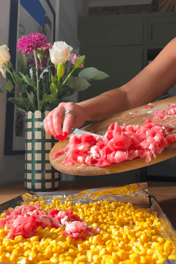 Sweetcorn and cooking bacon spread across a baking tray, roasted until charred and crisp.