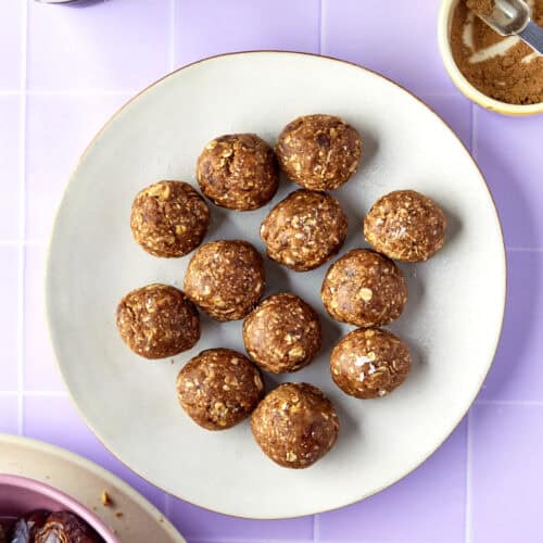 Overhead shot of energy balls with dates stacked, finished with a sprinkle of flaky sea salt.