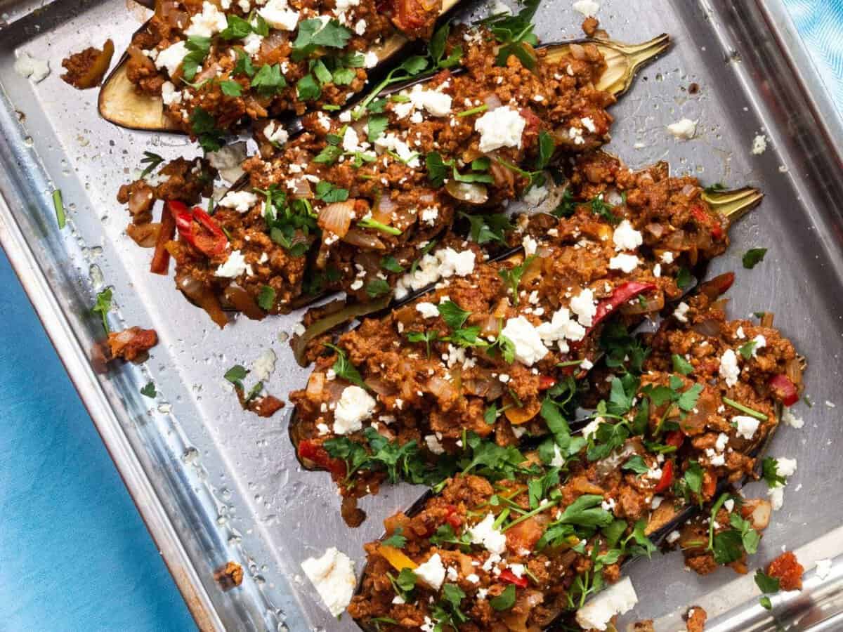 Baking aubergine halves stuffed with vegetarian mince and feta