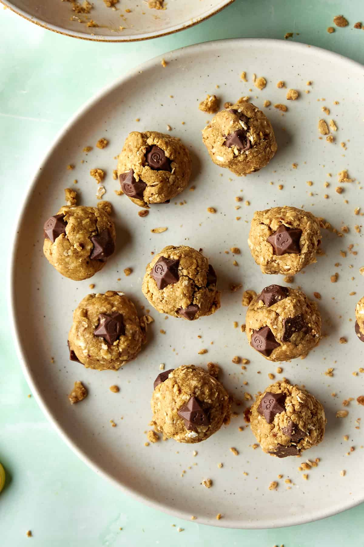 Close-up of a no-bake protein ball broken in half, showing the soft oat and peanut butter dough studded with chocolate.