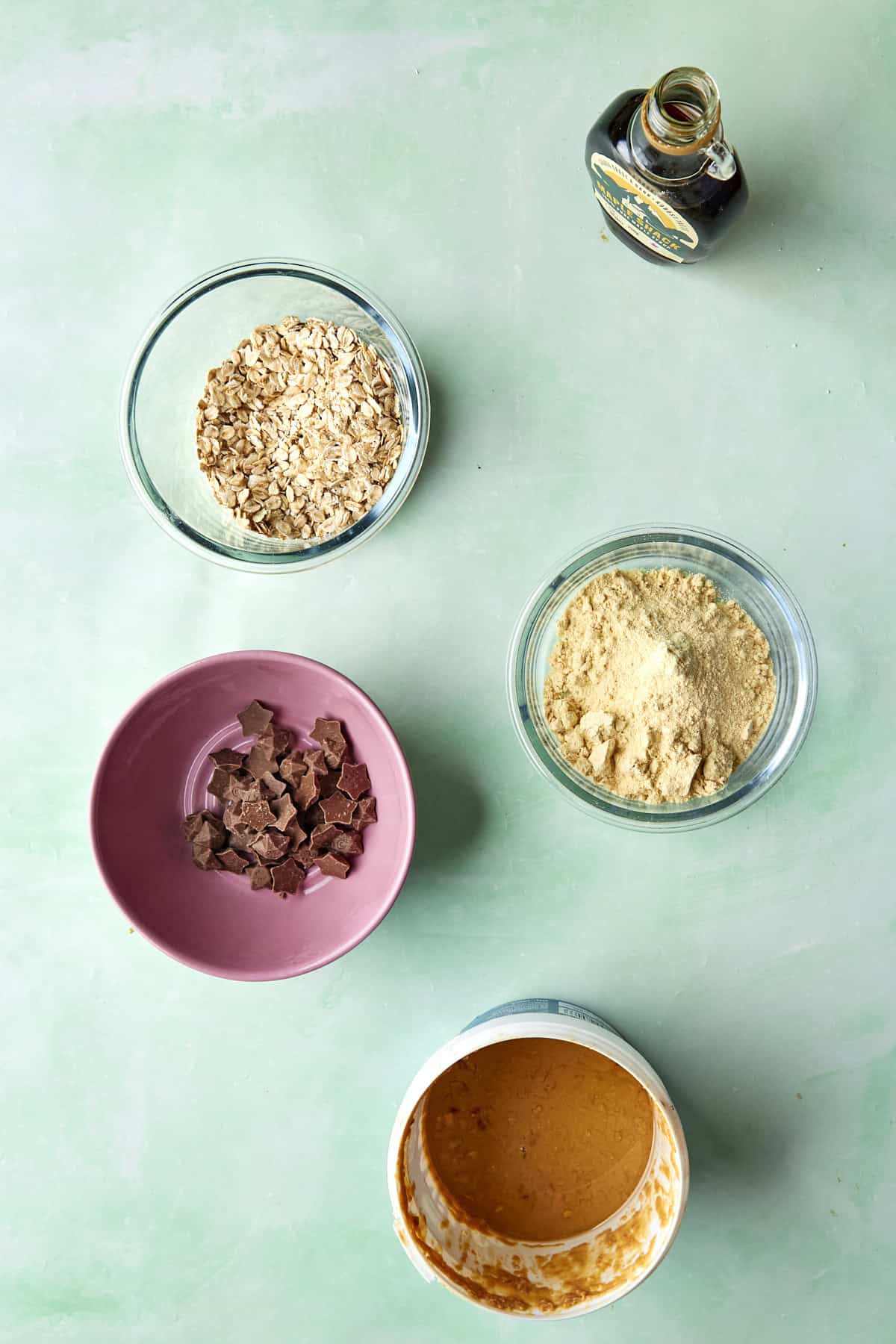 Ingredients for no-bake protein balls laid out, including oats, peanut butter, vanilla protein powder and Magic Stars.
