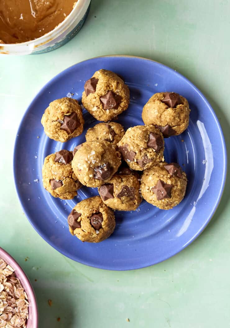 Overhead shot of no-bake protein balls stacked, studded with melted chocolate pieces.