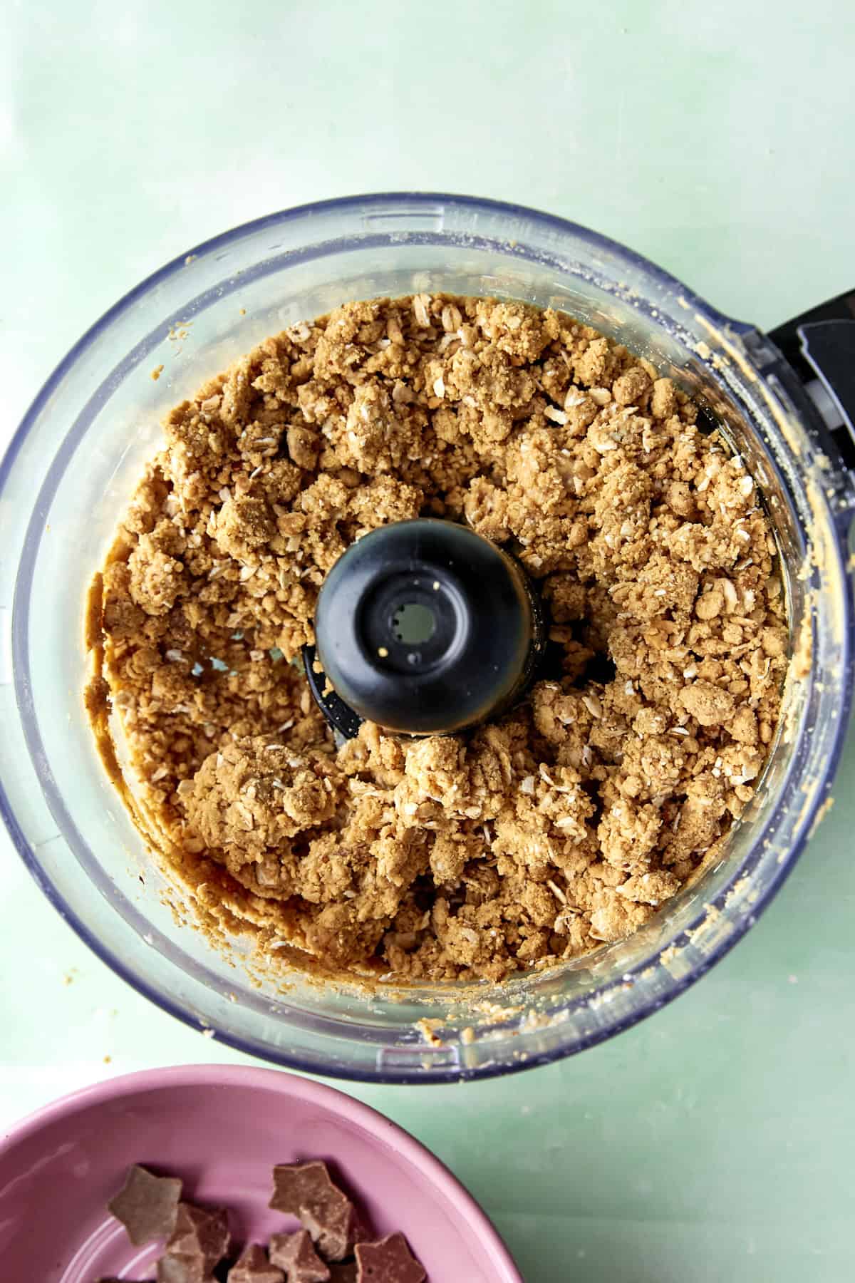 Peanut butter, vanilla protein powder and maple syrup being blitzed into a dough.