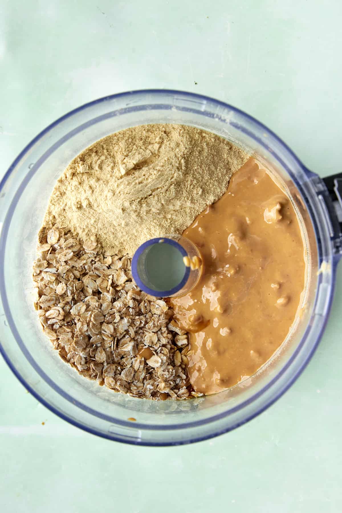 Rolled oats being blitzed to a rough flour in a food processor.