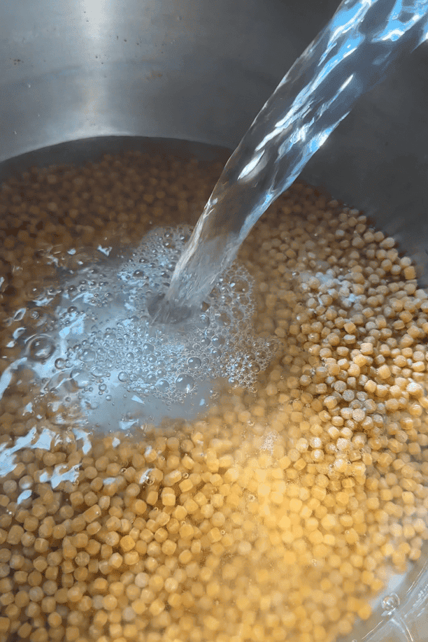 Giant couscous cooking in a pan of boiling salted water.