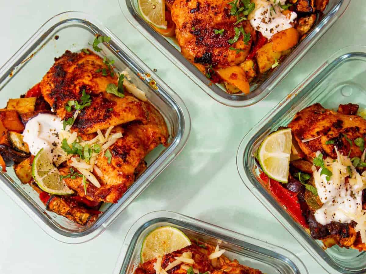 4 square glass meal containers with Low Carb Mexican Inspired Chicken with broccoli, peppers, red onion with sour cream, cheese and limes.