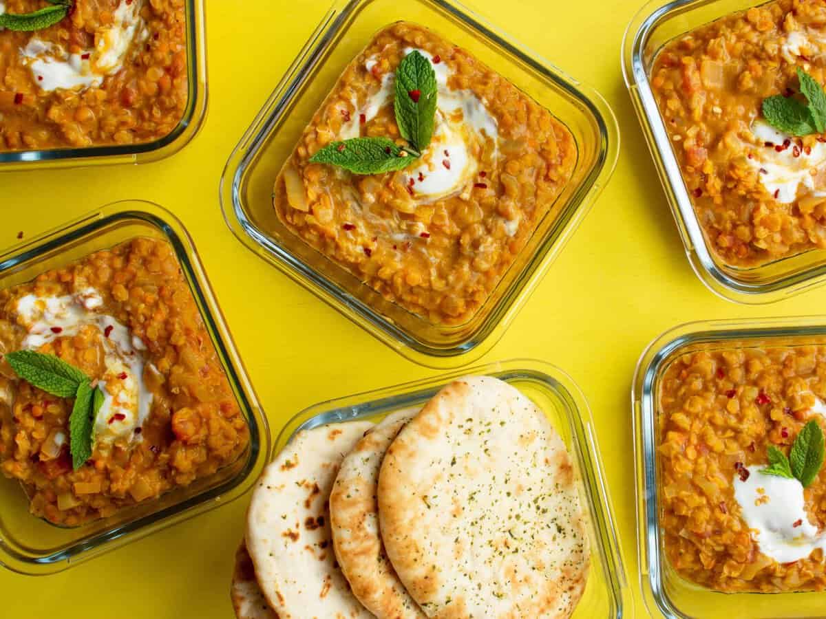 Overhead shot of meal prep containers with red lentil curry