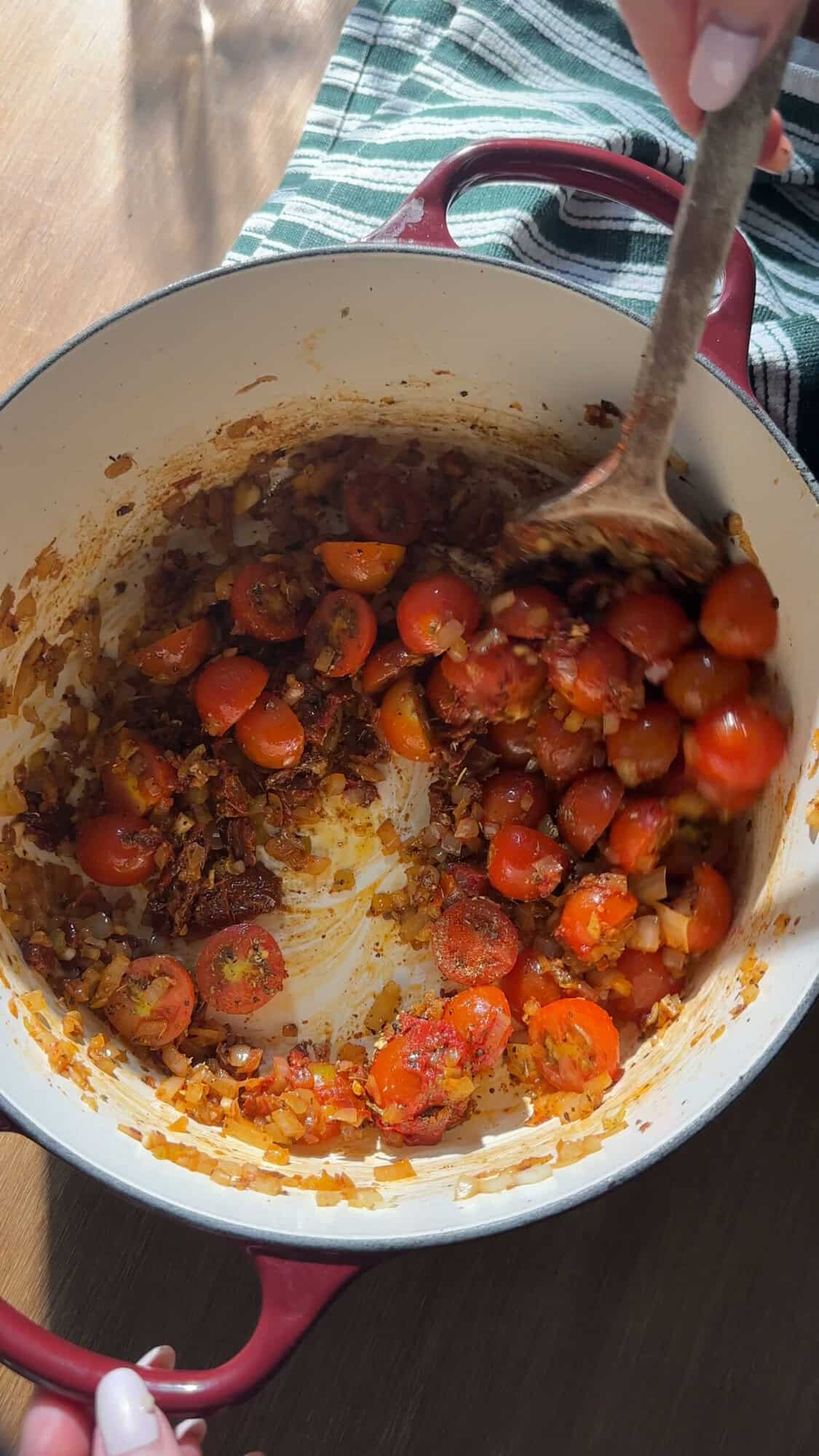 Tomato puree, cherry tomatoes and spices stirred into the pot.