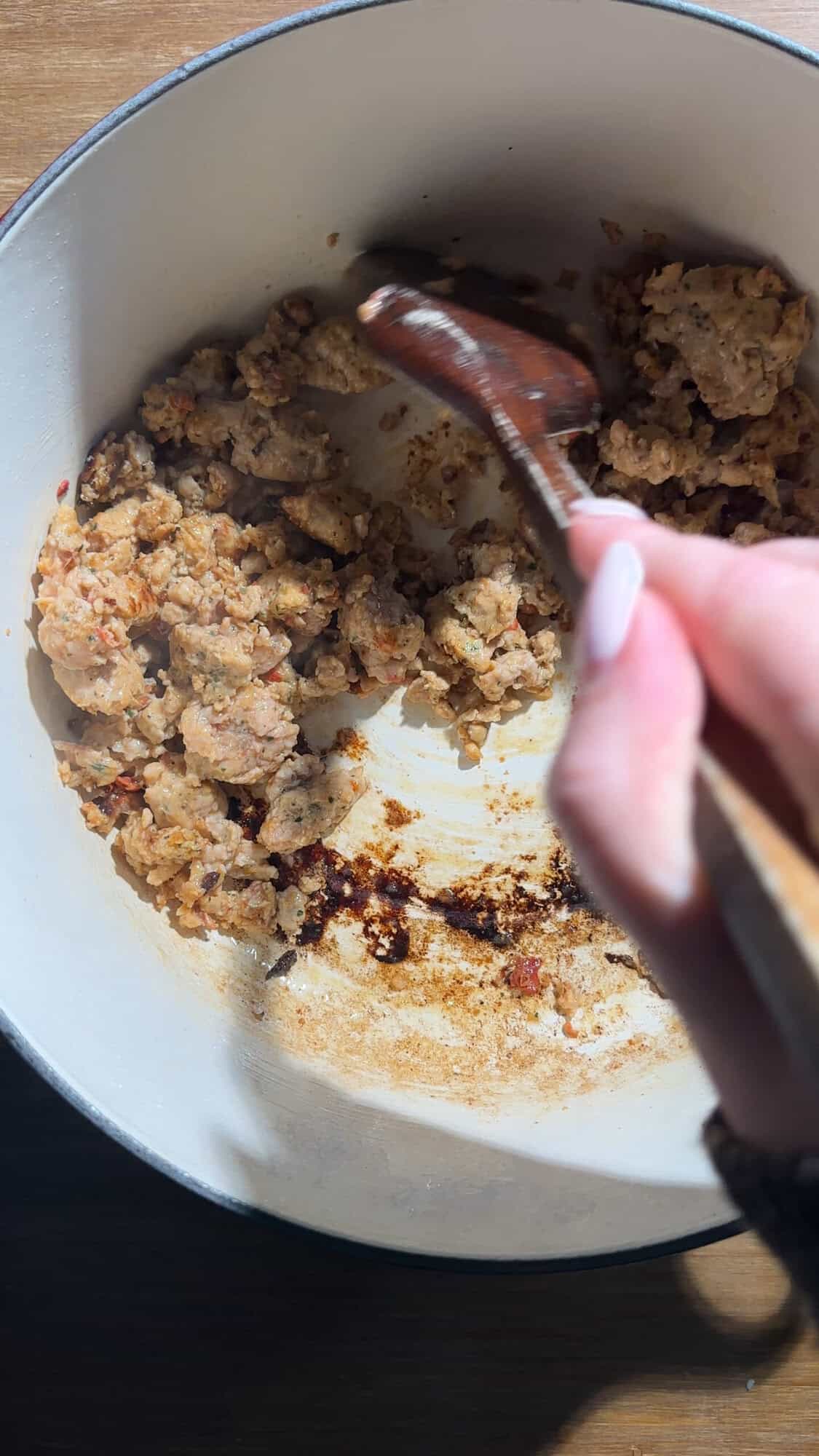 Sausagemeat browning in a large pot for tuscan gnocchi soup.