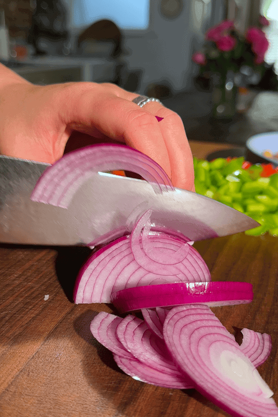 Thinly sliced red onion quick-pickling in vinegar and water.