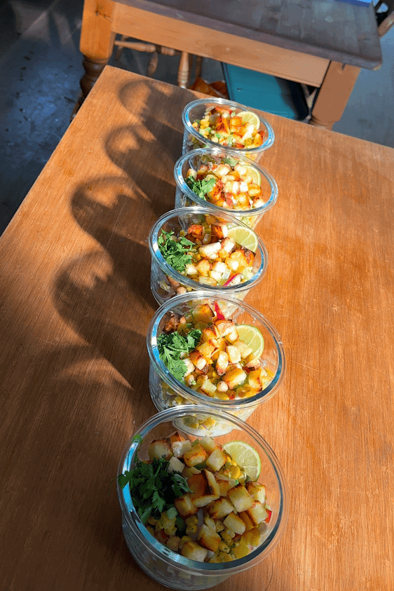 Hot honey halloumi bowl topped with dressing, hot honey and a lime wedge.